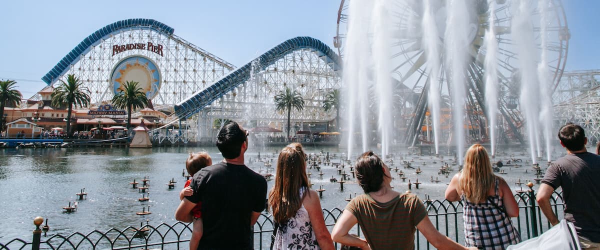 Disney California Adventure® Park which includes rides and a fountain as well as a small group of people
