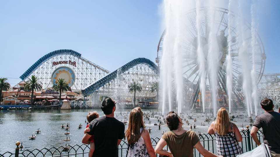 Disney California Adventure® Park which includes rides and a fountain as well as a small group of people