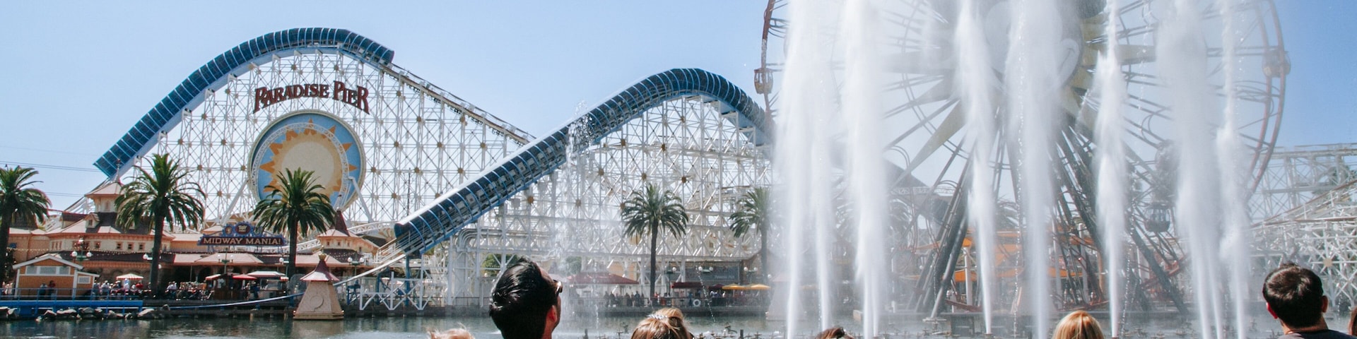 Disney California Adventure® Park which includes rides and a fountain as well as a small group of people