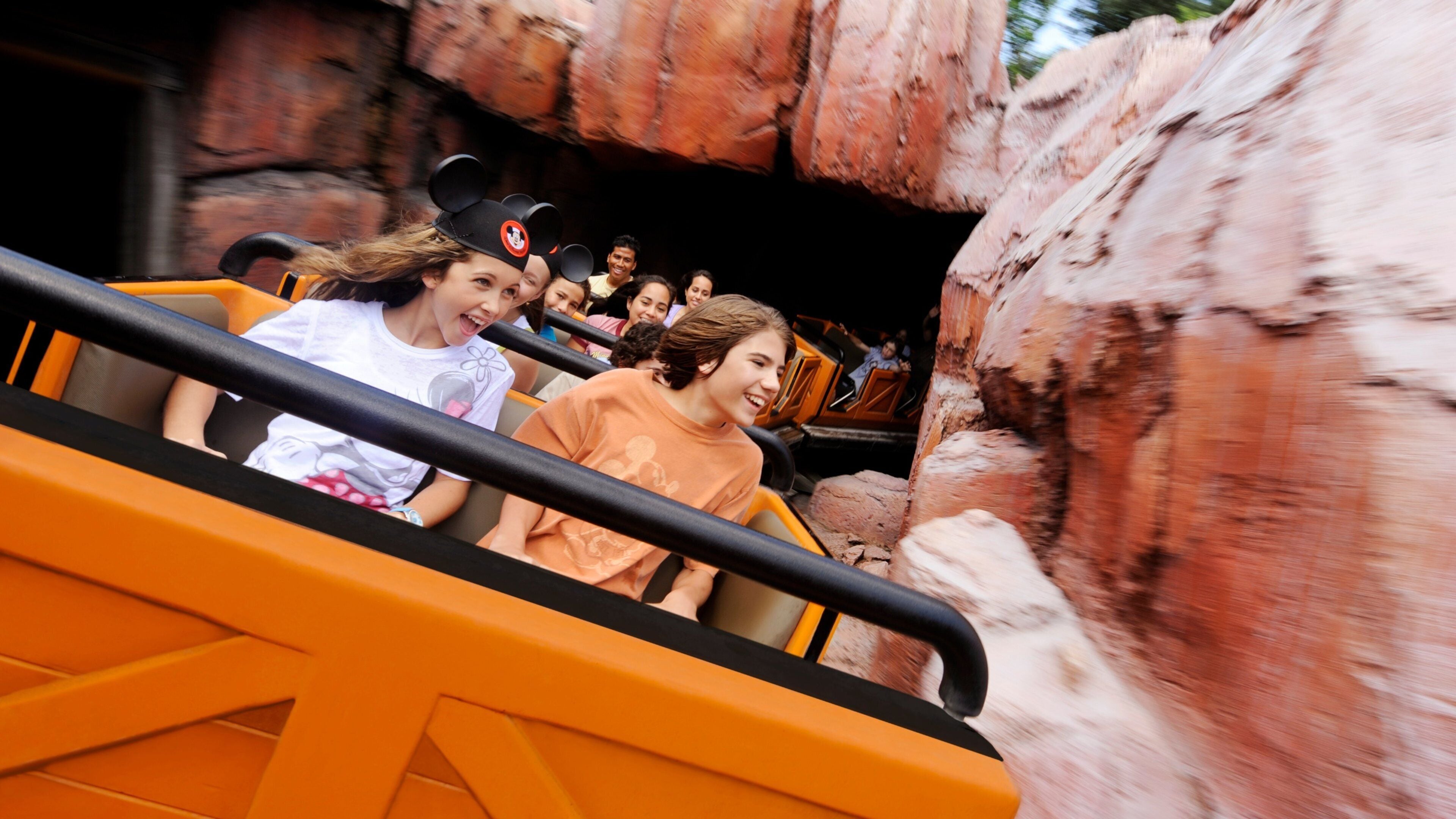 Excitement on a roller coaster at a popular theme park in Florida during a sunny afternoon