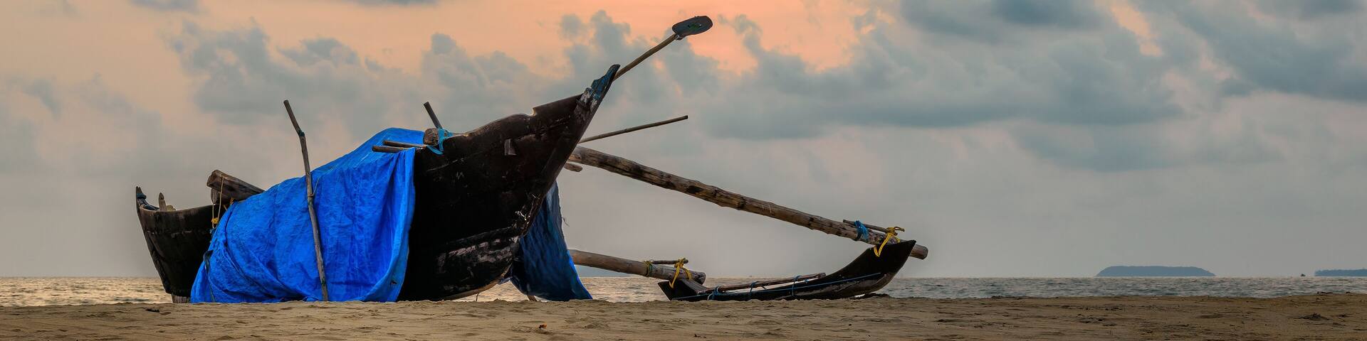 Fishing boat on a beach at sunset in India
