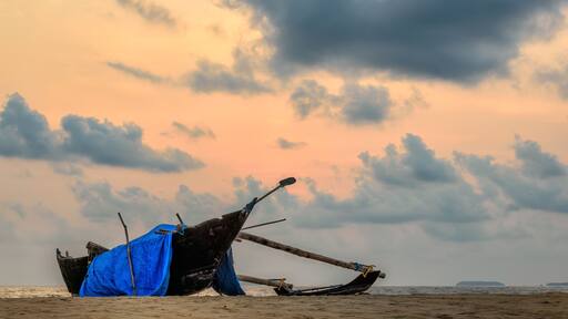 Fishing boat on a beach at sunset in India