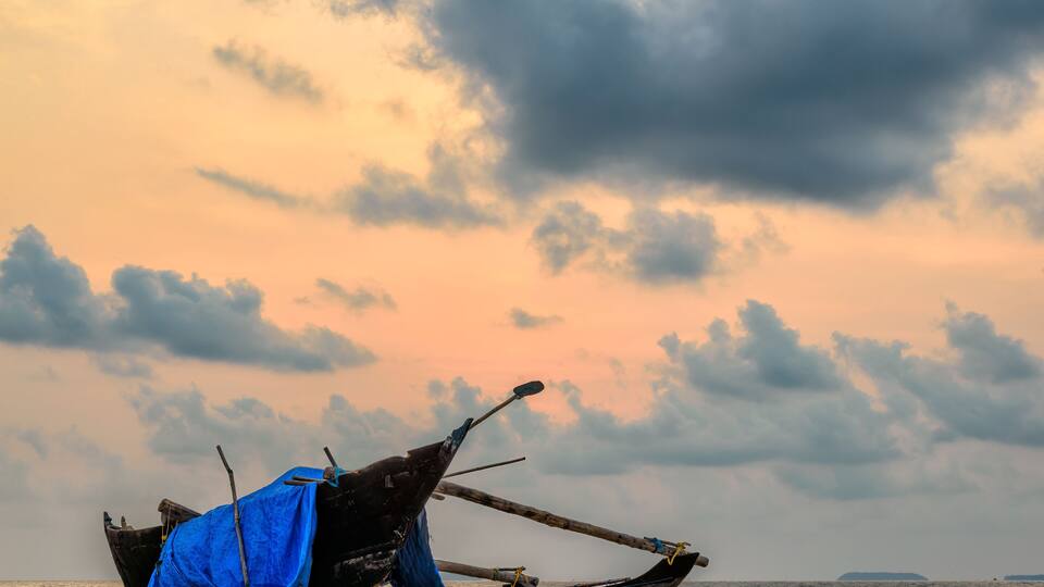 Fishing boat on a beach at sunset in India