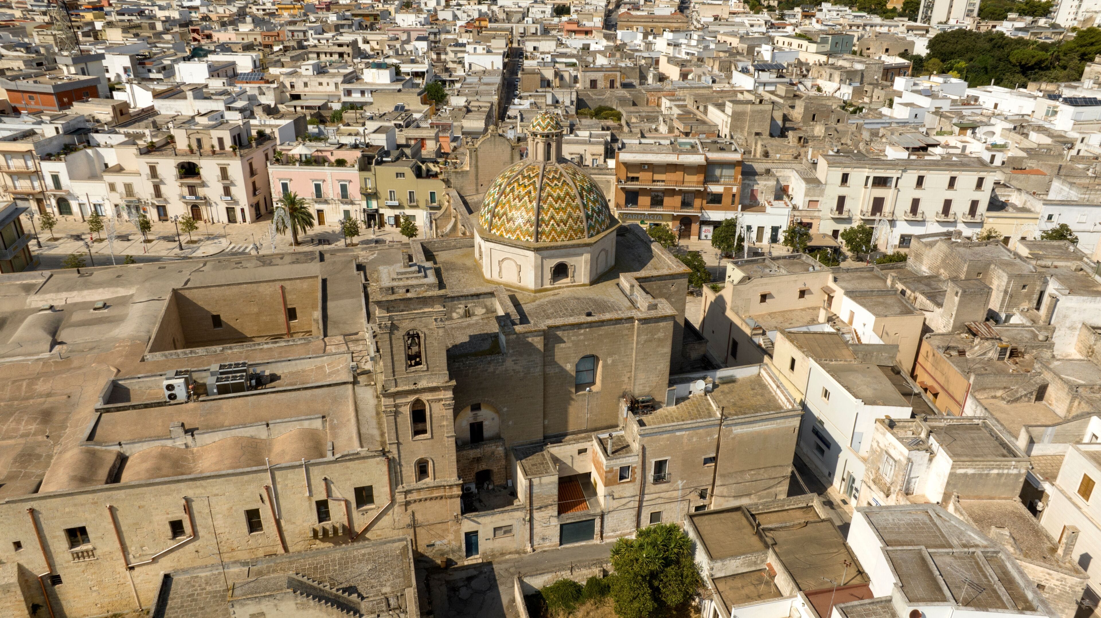 A densely packed urban area with a prominent golden-domed building, narrow streets, and traditional architecture.