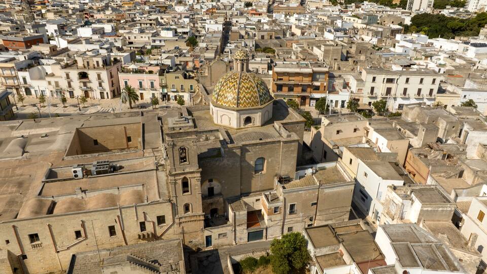 A densely packed urban area with a prominent golden-domed building, narrow streets, and traditional architecture.