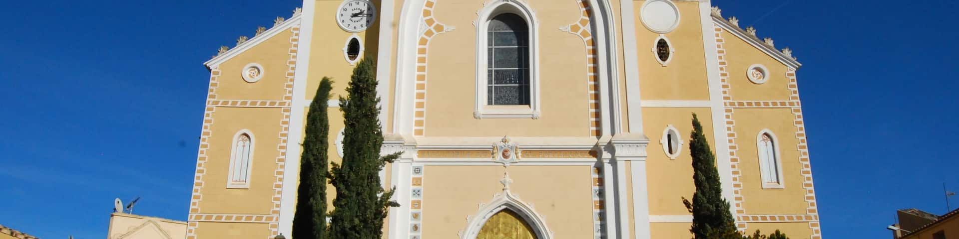 A church with a bell tower, a golden door, and a clock.