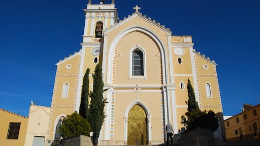 Une église dotée d’un clocher, d’une porte dorée et d’une horloge.