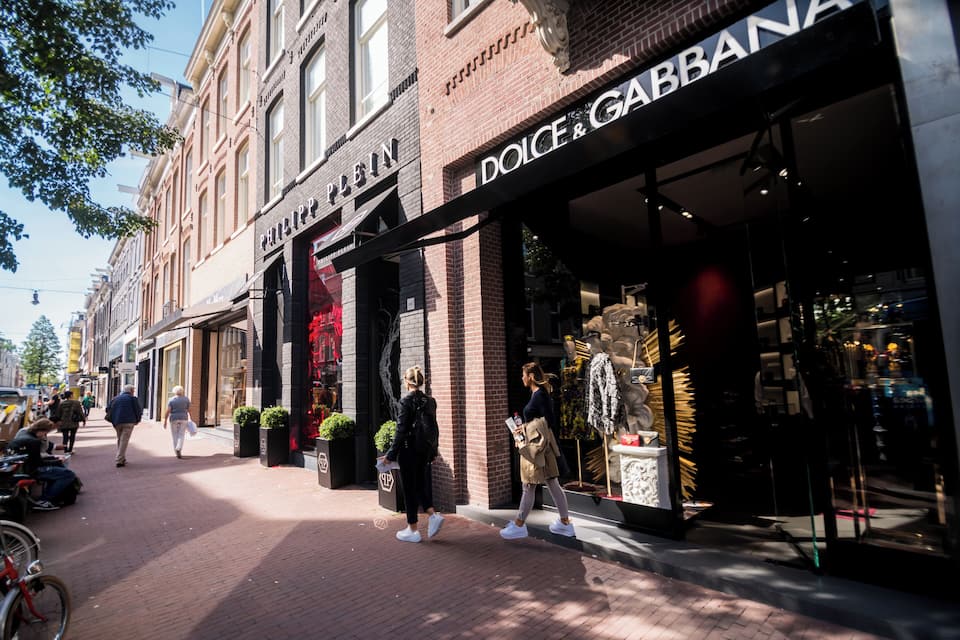 Eine Straße mit Geschäften, darunter ein Dolce & Gabbana Geschäft.