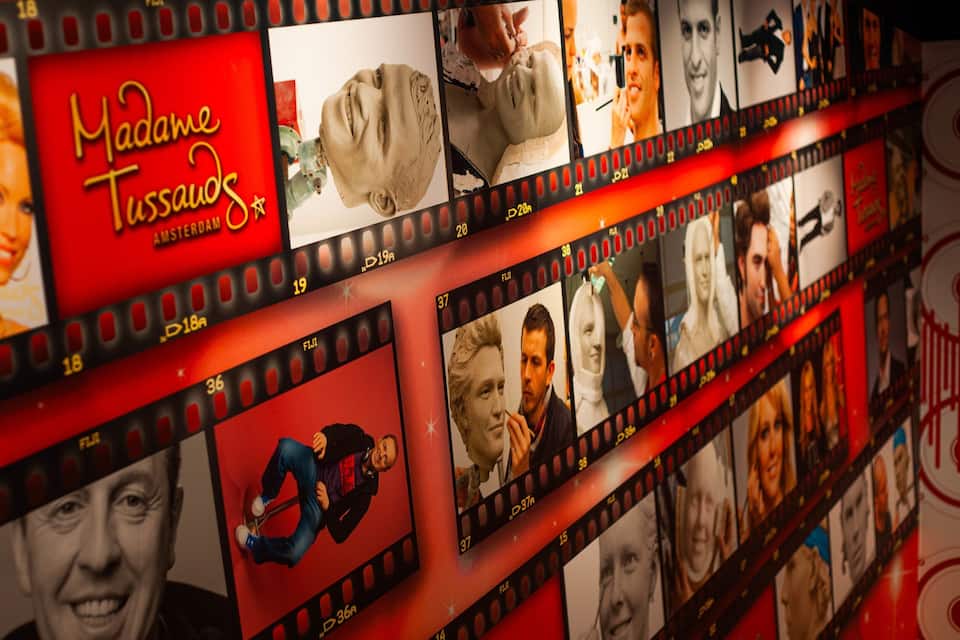 A film strip with various movie posters, including 'Madame Tussauds'.