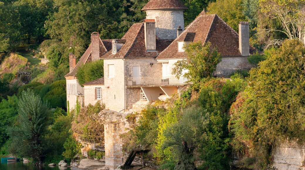 Two women paddleboarding no the River Dordogne in Meyronne, Lot, France, beneath a beautiful chateau