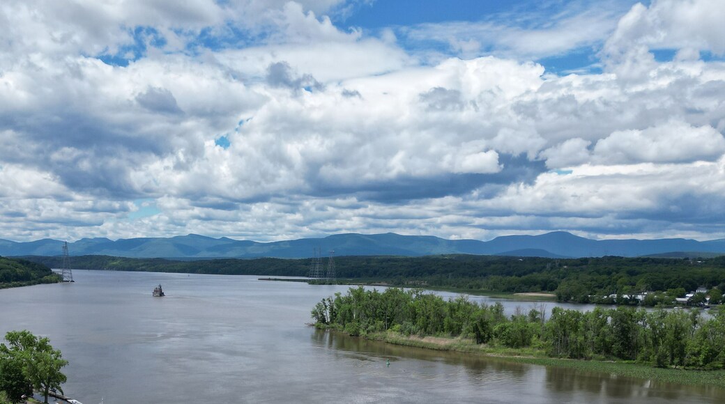 view of the hudson river and catskills mountains from a park in hudson new york valley (lighthouse, water clouds harbor coastline scene) aerial beautiful travel destination ny state public land