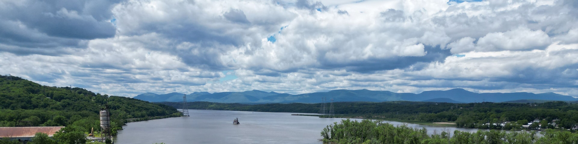 view of the hudson river and catskills mountains from a park in hudson new york valley (lighthouse, water clouds harbor coastline scene) aerial beautiful travel destination ny state public land