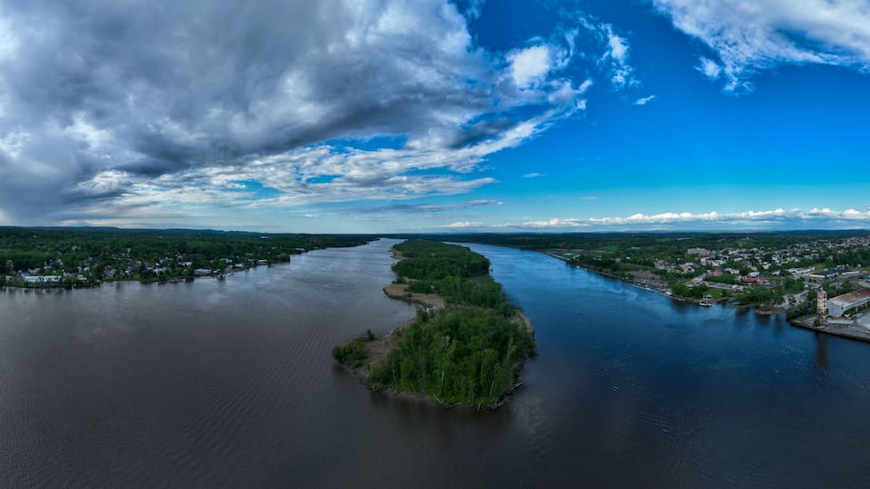 A river winding through a town with a prominent island in the center.