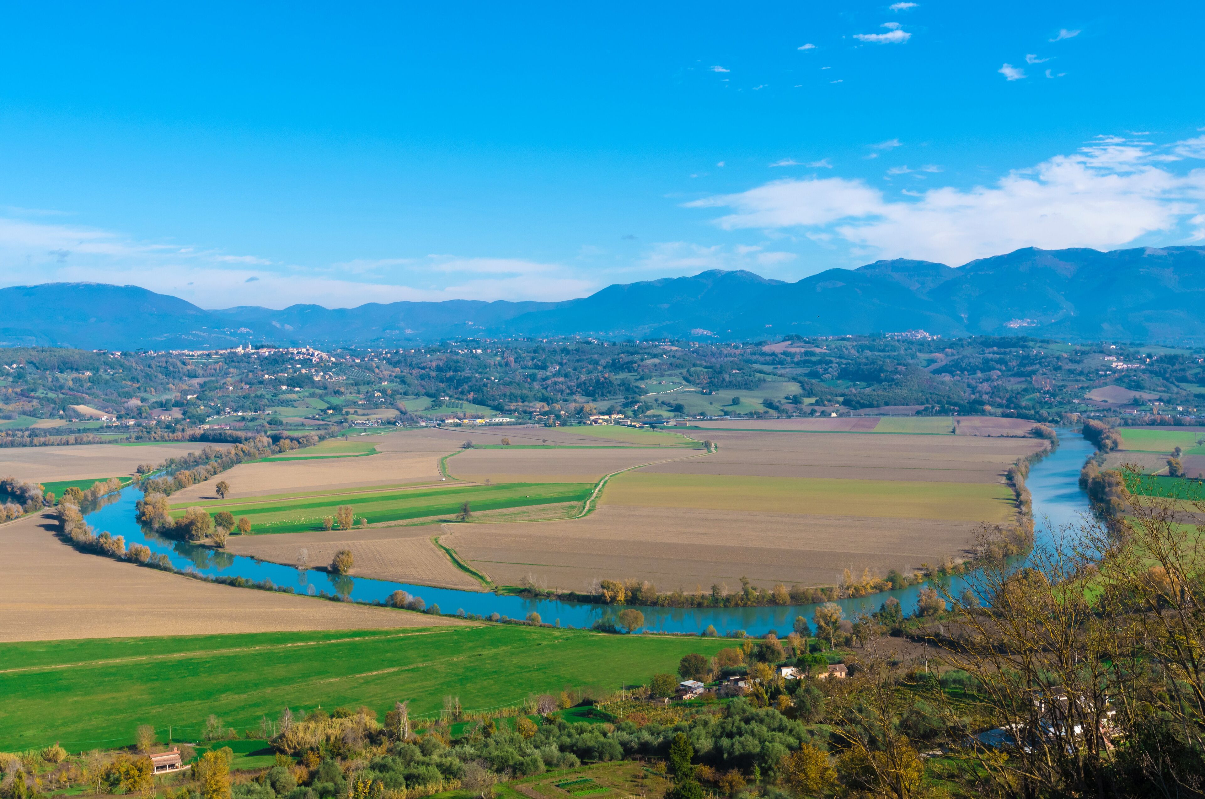 A river winding through green fields and a town in the valley.