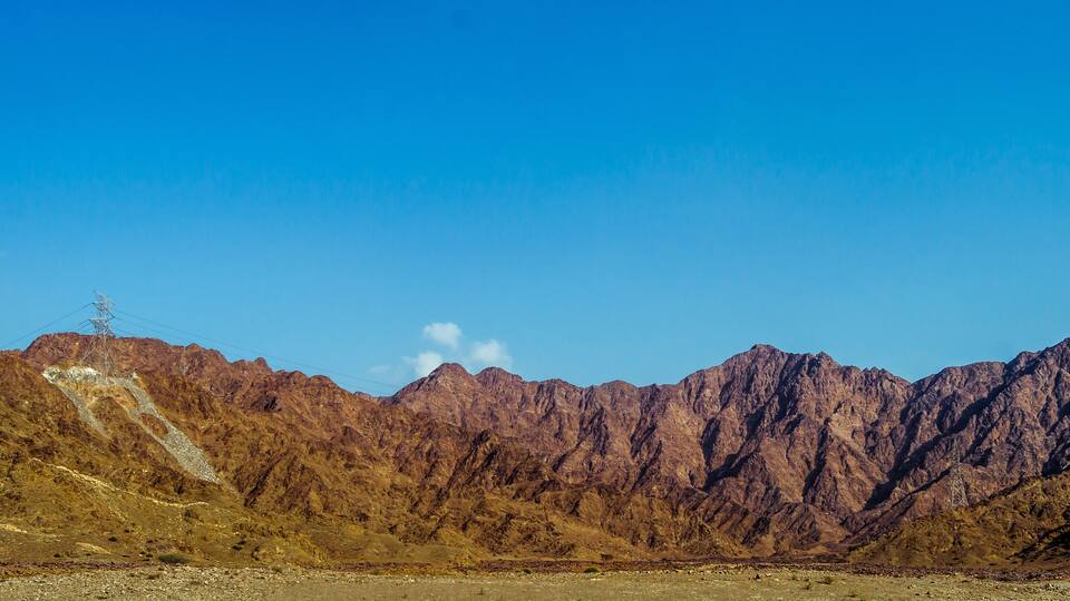 A mountainous landscape with rocky terrain and a clear blue sky.