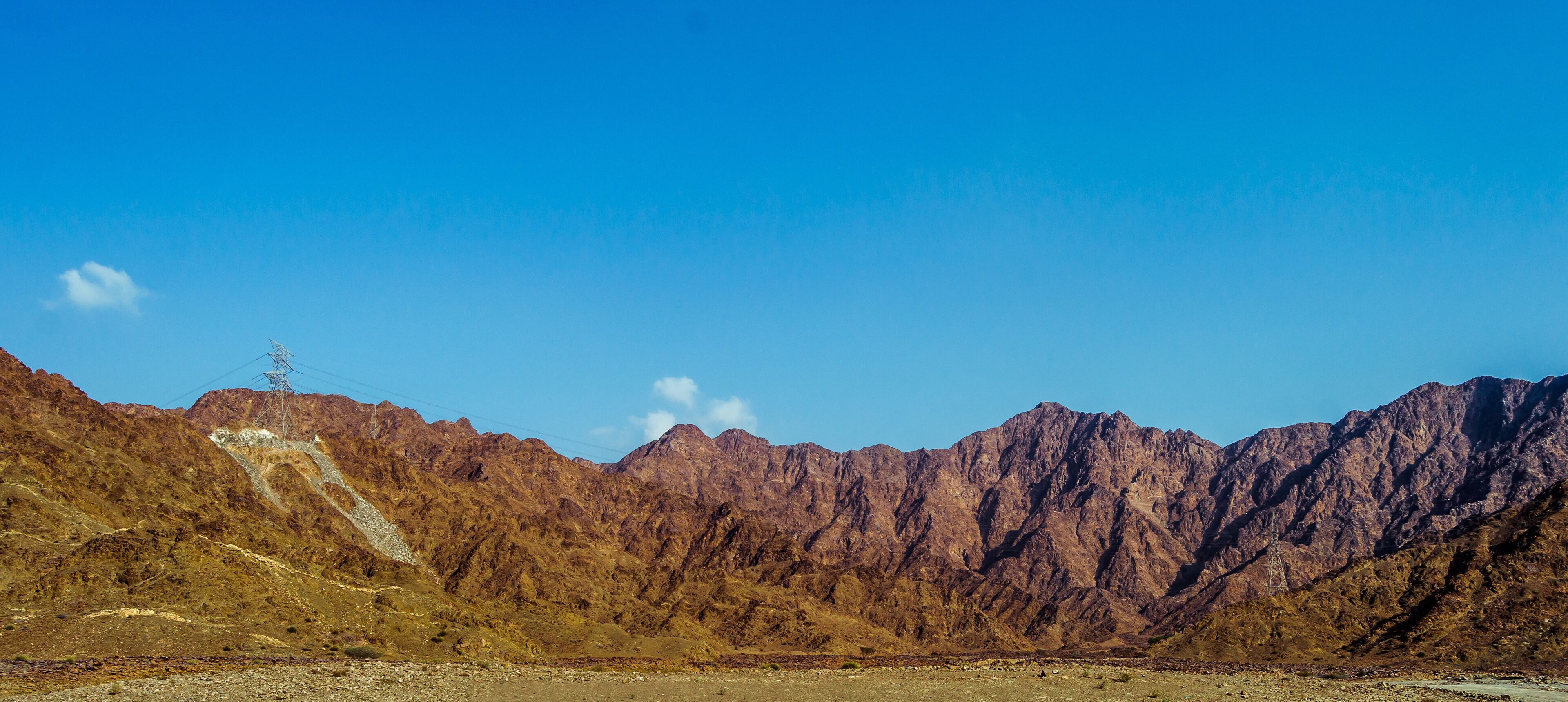 A mountainous landscape with rocky terrain and a clear blue sky.