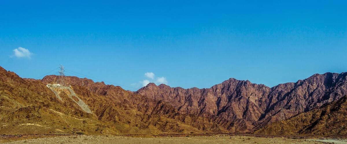 A mountainous landscape with rocky terrain and a clear blue sky.