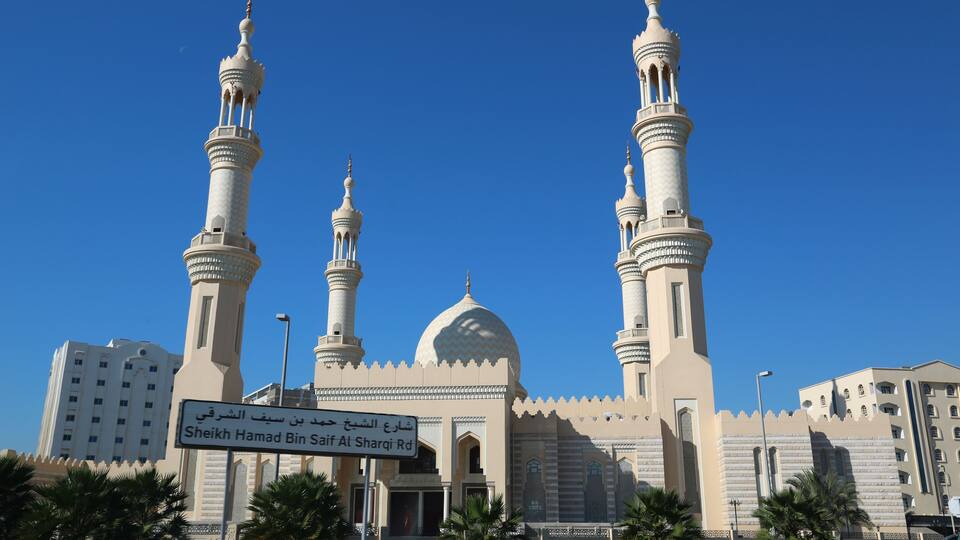 A mosque with three minarets and a large dome.