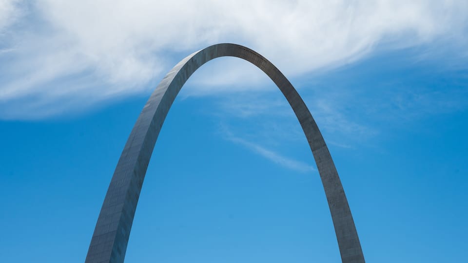 A large arch structure against a clear blue sky.