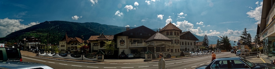 Un pueblo con un edificio destacado identificado como "Hotel Rossl" y una montaña al fondo.