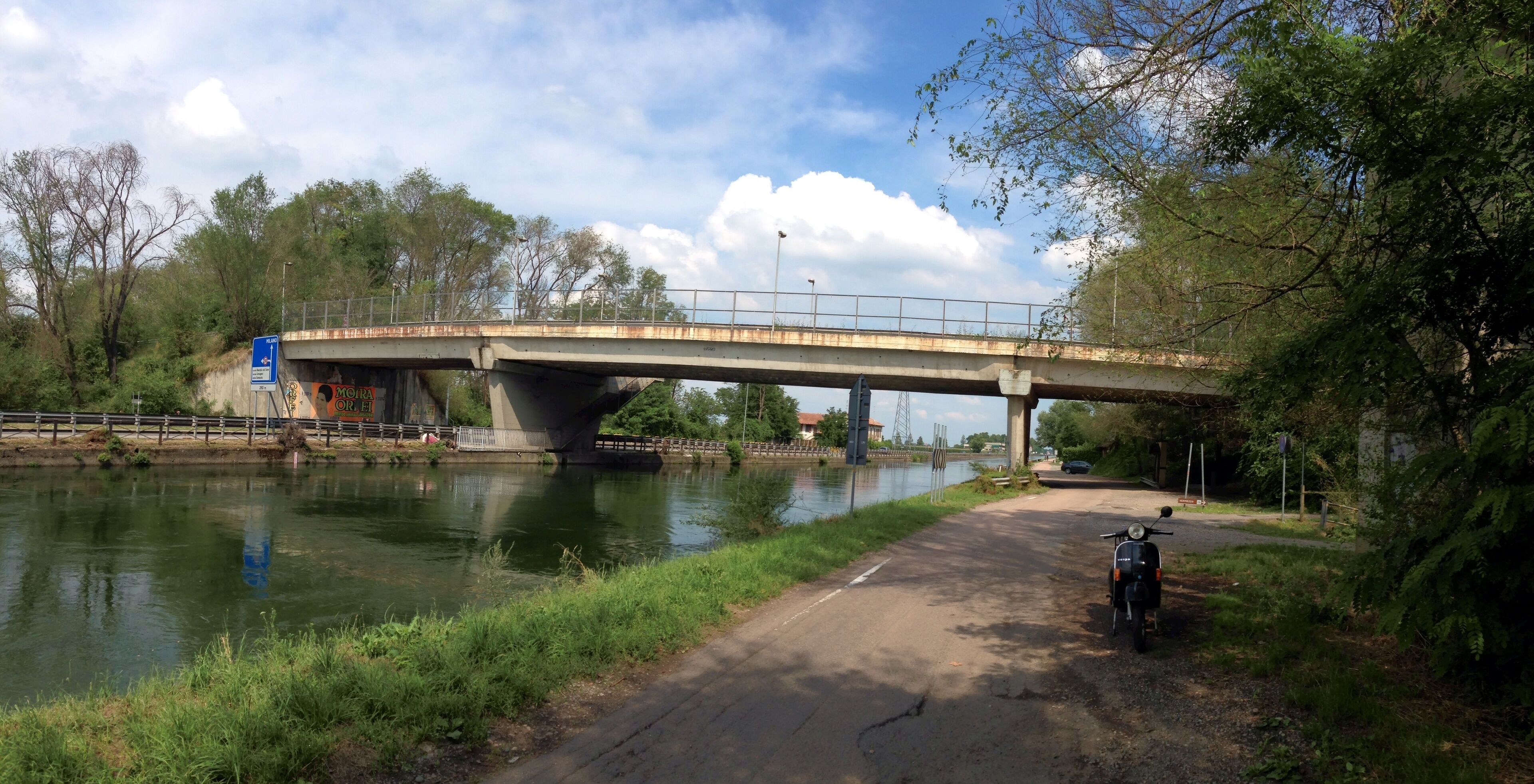 A bridge over a river with a scooter parked nearby.