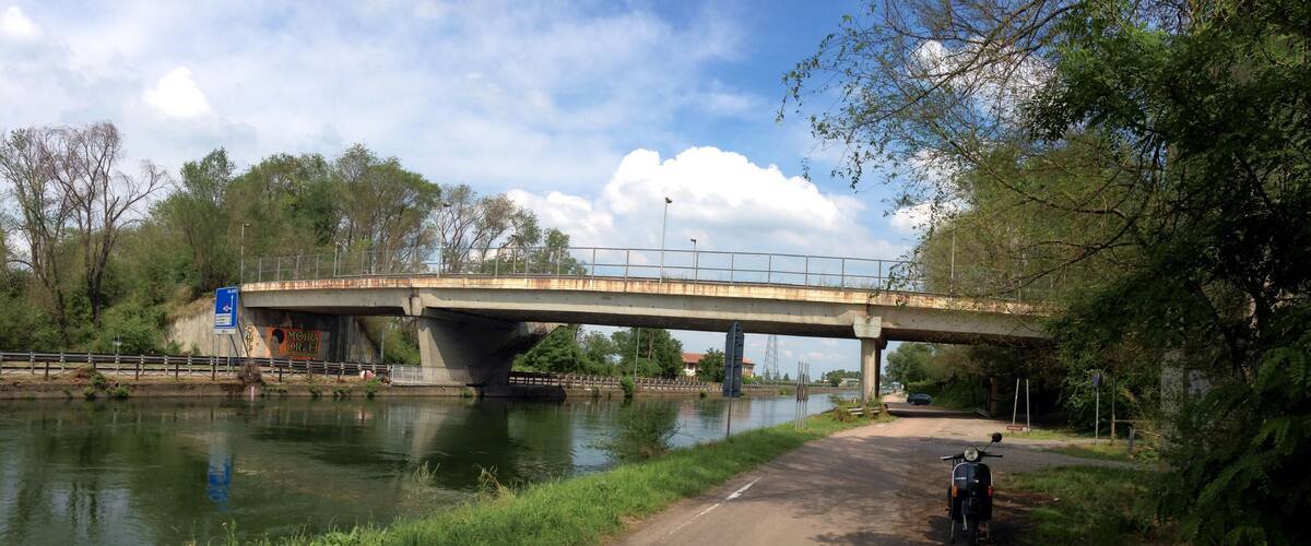 A bridge over a river with a scooter parked nearby.