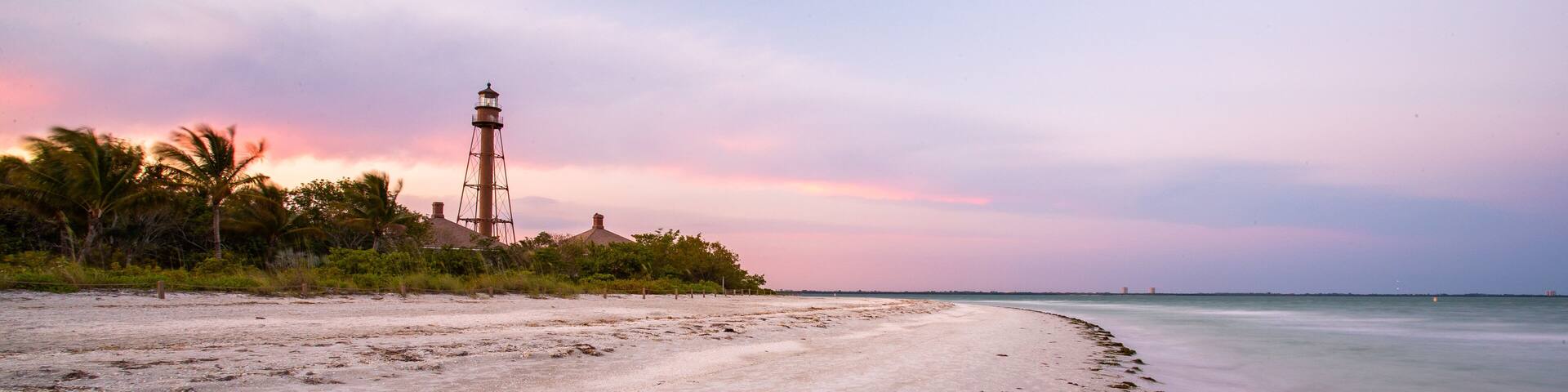 Sanibel Island Lighthouse which includes a beach, general coastal views and a sunset