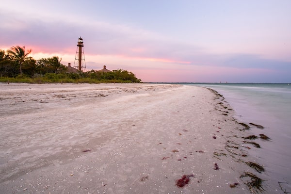 Sanibel Island Lighthouse which includes a beach, general coastal views and a sunset
