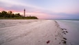 Sanibel Island Lighthouse which includes a beach, general coastal views and a sunset