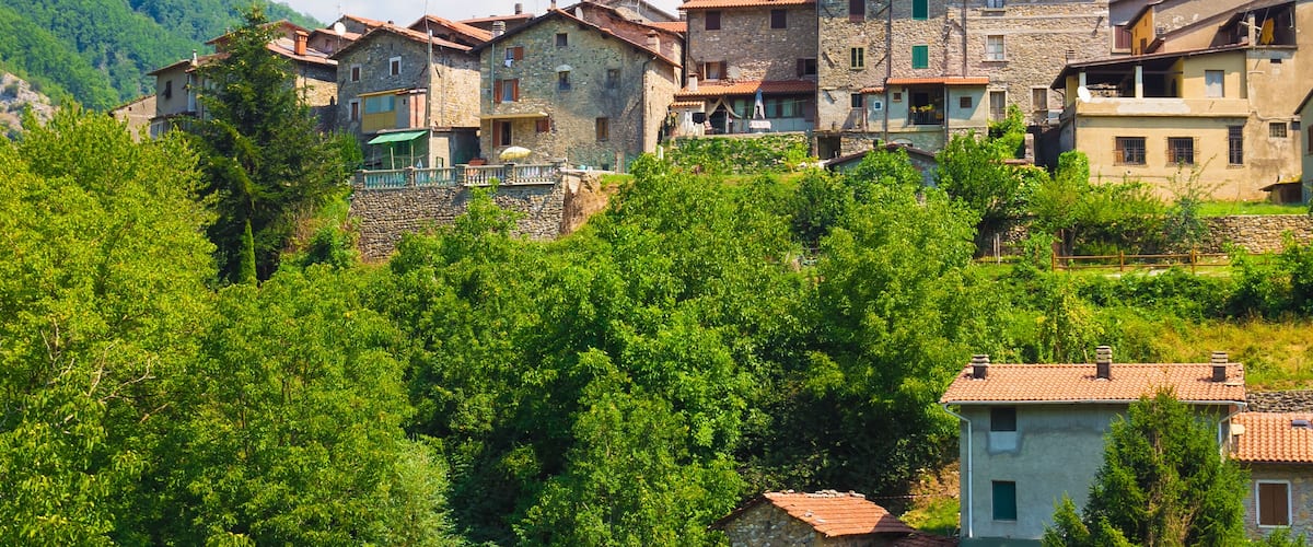 A village with stone buildings and a church tower.