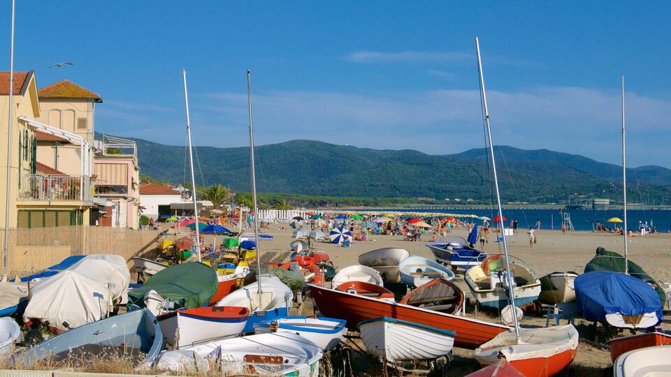 A beach with boats and a mountainous backdrop.