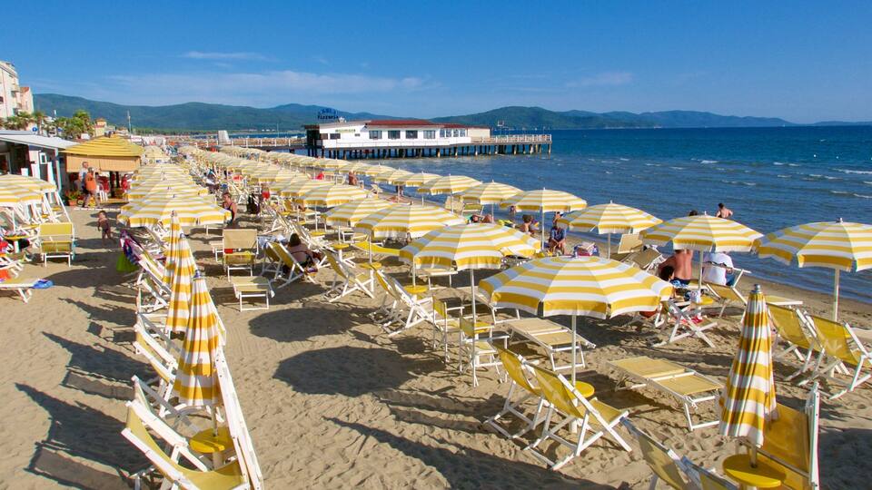 A beach with yellow and white striped umbrellas and sun loungers.