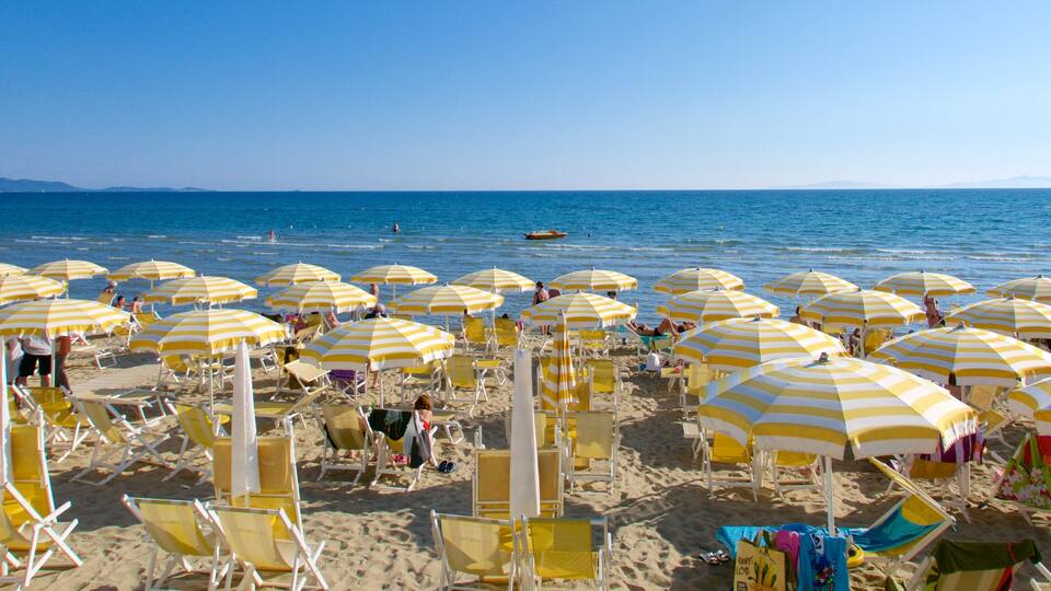 A beach with yellow and white striped umbrellas and sun loungers.