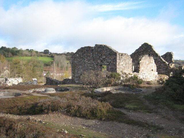 A historical stone structure with ruins in a rural landscape.