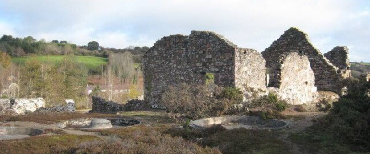 A historical stone structure with ruins in a rural landscape.