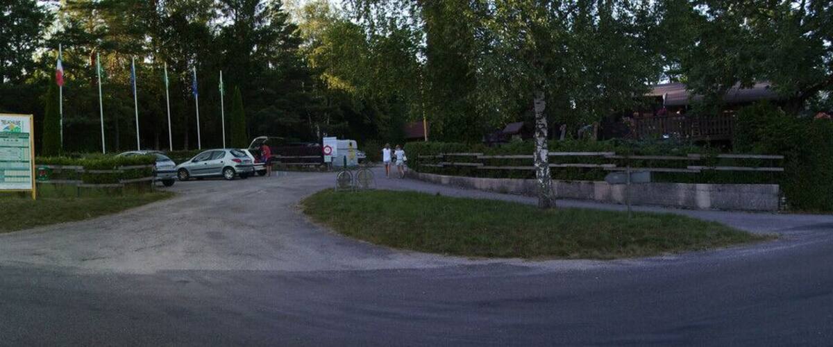 A road leading to a camping area with a lake in the background.