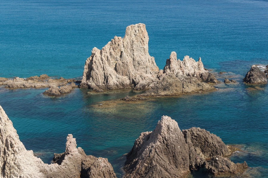 Una costa rocosa con aguas azul cristalino y destacadas formaciones de piedra caliza.