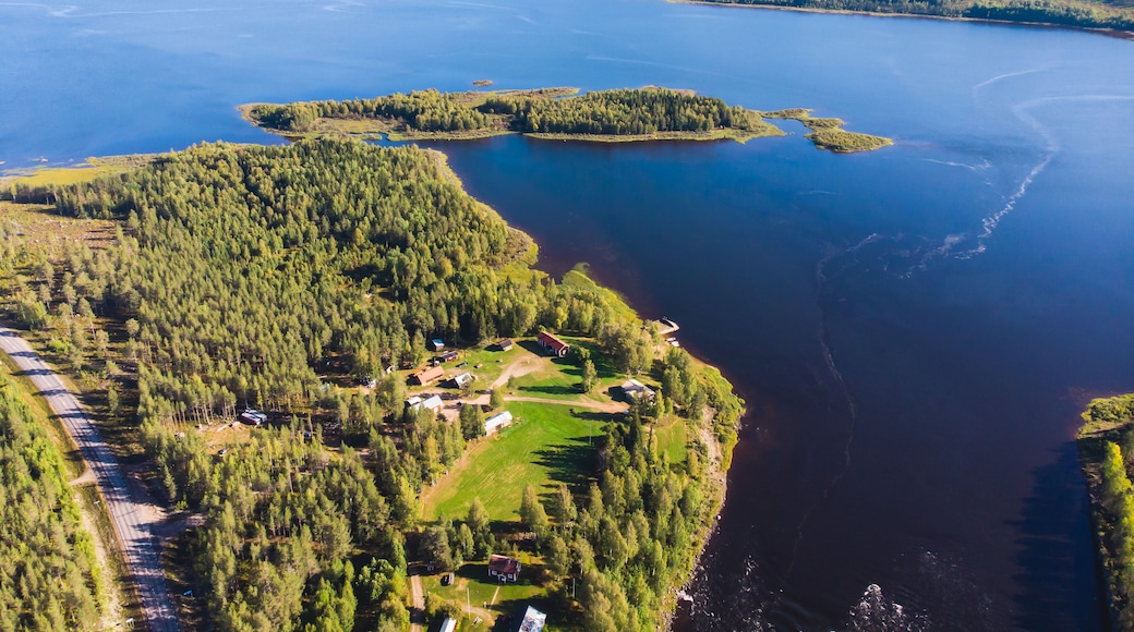 View of Kalix river, Kalixalven, Overkalix locality and the seat in Norrbotten county, Sweden, with forest in sunny summer day, aerial drone view