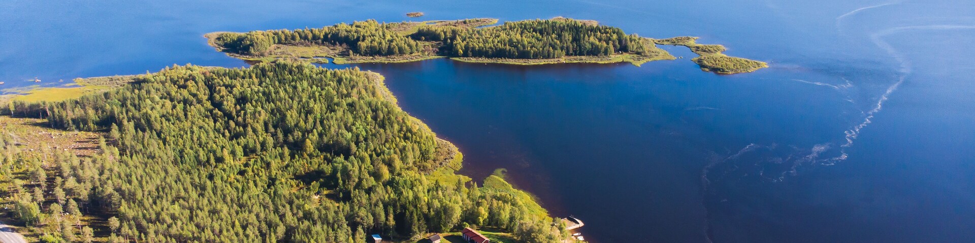 Un lago rodeado de bosques frondosos y pequeñas islas.