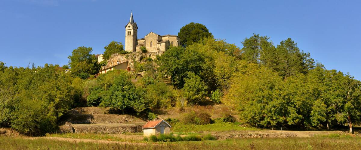 A historic church on a hill surrounded by lush greenery.