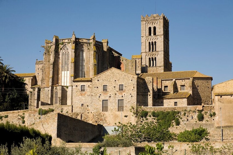 Una iglesia de piedra histórica con un campanario y un amplio ventanal de arco.