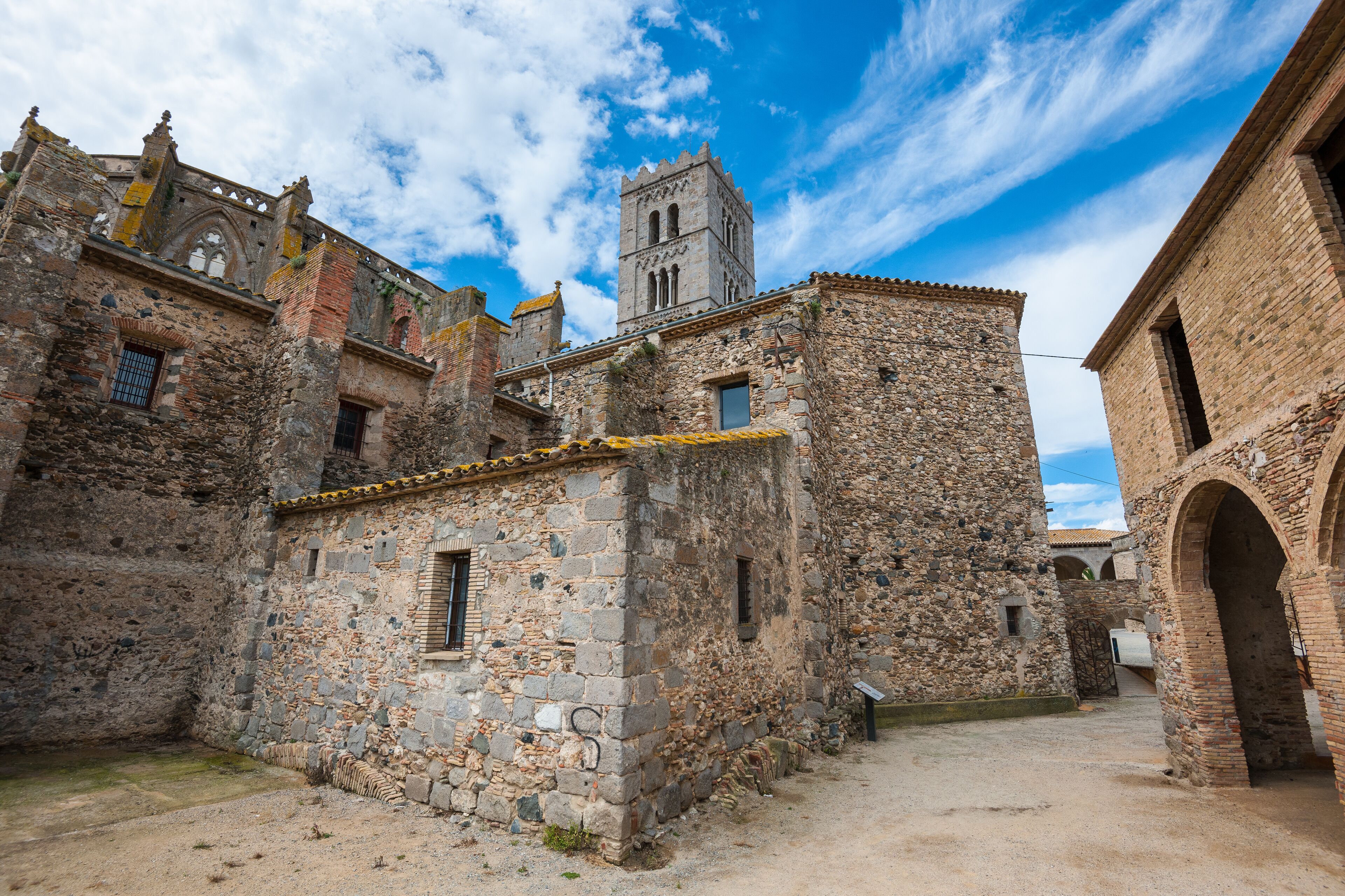 An old stone building with a tower, surrounded by other historic structures.