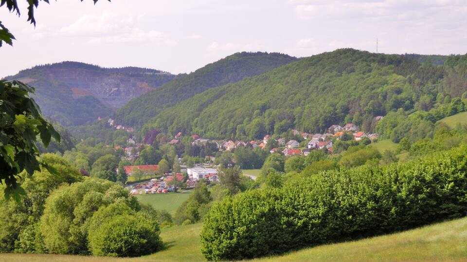 A valley with a small town nestled among green hills.