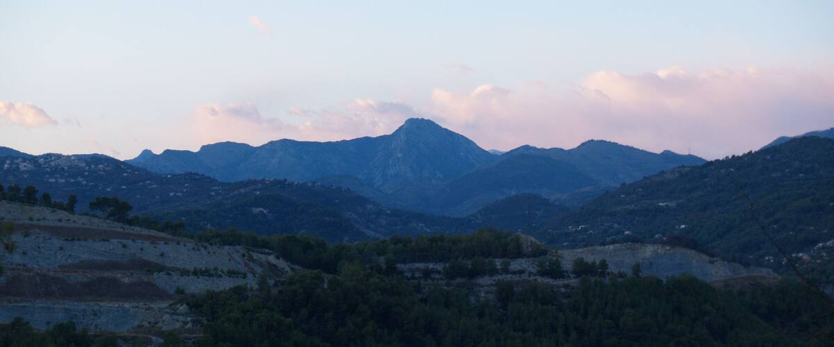 A mountainous landscape with dense forests and a clear sky.