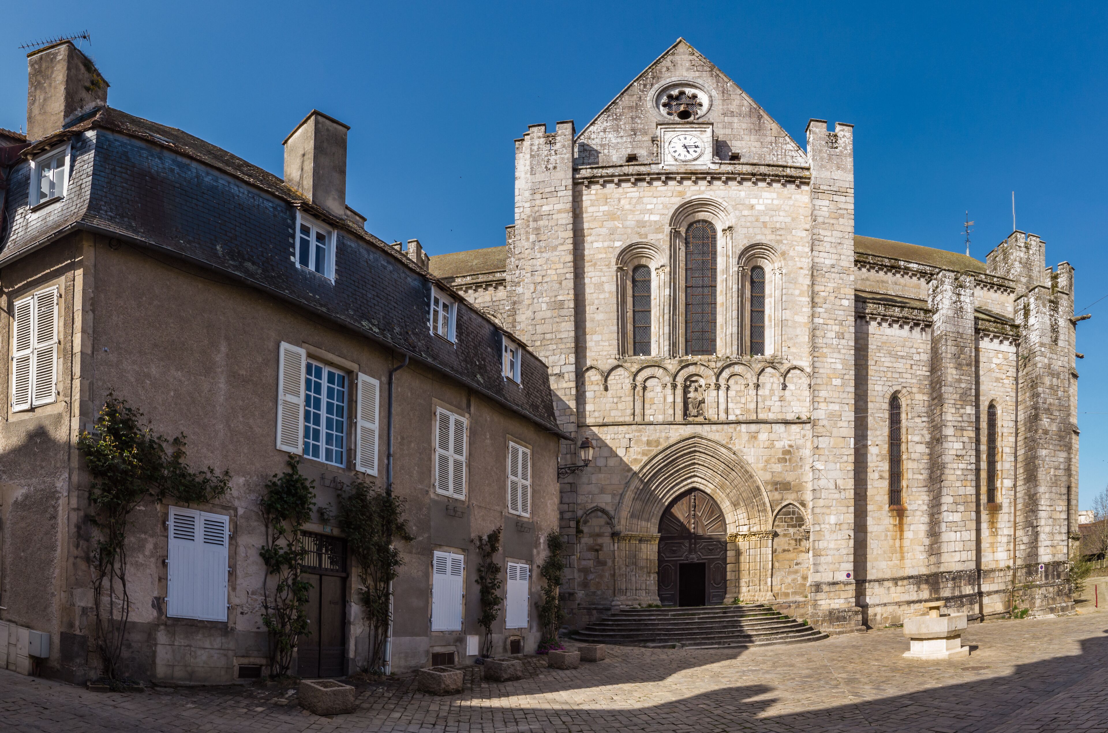 A historic stone building with a clock tower and arched windows.