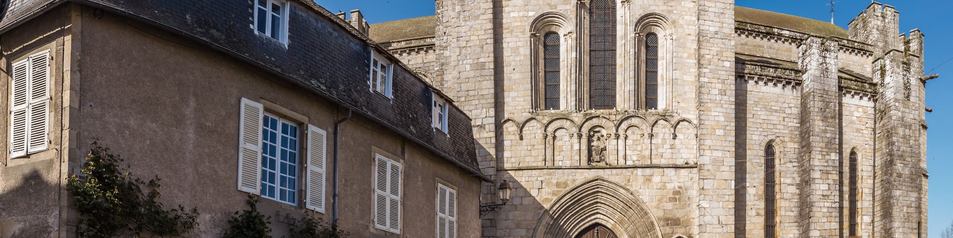 A historic stone building with a clock tower and arched windows.