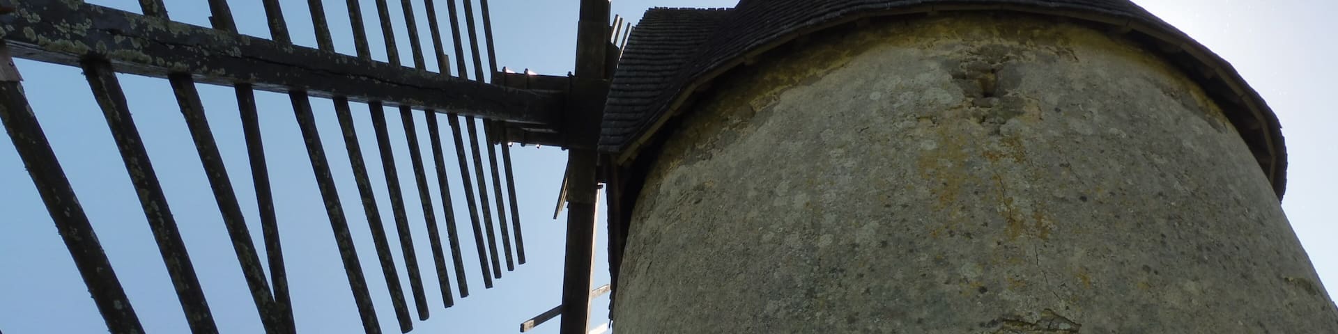 A windmill with a weathered structure and a pointed roof.