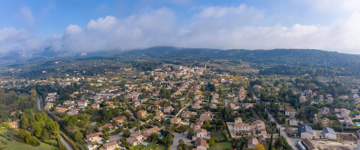 A sprawling residential area with houses, roads, and a river.