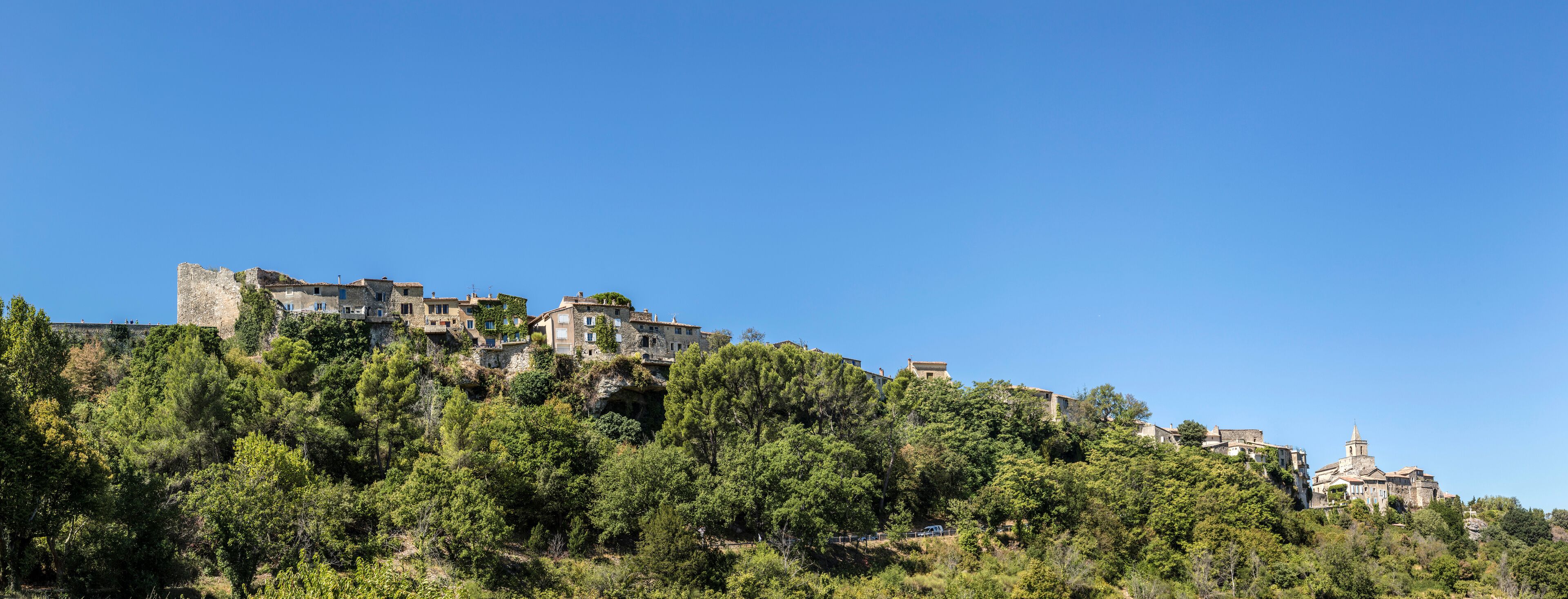 A hillside village with historic stone buildings and a church.