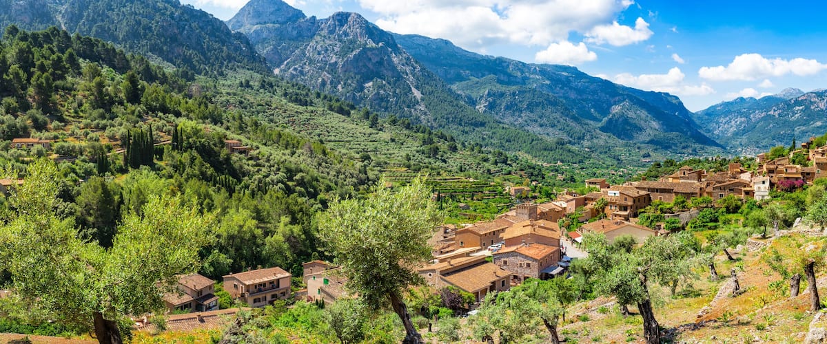 A mountainous village with terraced fields and traditional buildings.